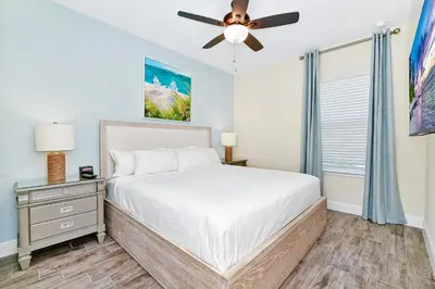 a bedroom with a bed and a ceiling fan at Breezy Blue Villa Near Disney With Margaritaville Resort & Island H20 Waterpark Access - 2952Cs in Orlando