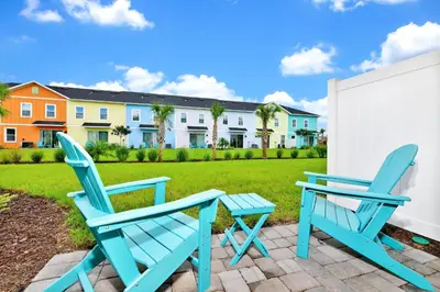 two blue chairs and a table on a patio at Sun Filled Villa Near Disney With Margaritaville Resort & Island H20 Access - 8119Cp in Orlando