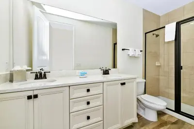 a white bathroom with a sink and a toilet at Sun Filled Villa Near Disney With Margaritaville Resort & Island H20 Access - 8119Cp in Orlando