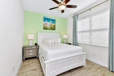 a bedroom with a white bed and a ceiling fan at Colorful Villa Near Disney With Margaritaville Resort & Island H20 Waterpark Access- 2919Cl in Orlando