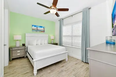 a bedroom with a white bed and a ceiling fan at Colorful Villa Near Disney With Margaritaville Resort & Island H20 Waterpark Access- 2919Cl in Orlando