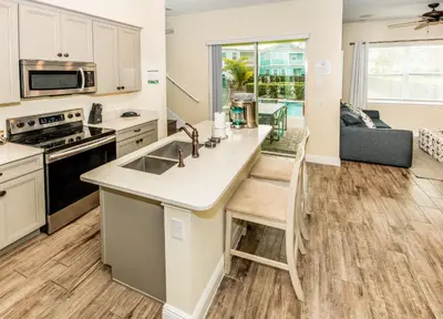 a kitchen and living room with a sink and a stove at Flip Flops And Tank Tops Cottage With Private Pool Near Disney With Margaritaville Resort & Island H2O Access - 8098Kd in Orlando