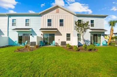 a large white house with a yard at Cozy Villa Near Disney With Margaritaville Resort & Island H20 Waterpark Access - 3009Cs in Orlando