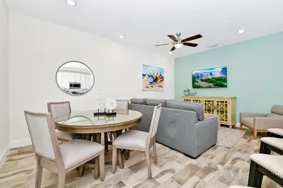 a living room with a table and chairs and a couch at Colorful Villa Near Disney With Margaritaville Resort & Island H20 Waterpark Access - 3128Cs in Orlando