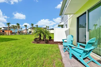 a pair of blue chairs sitting on the porch of a house at Colorful Villa Near Disney With Margaritaville Resort & Island H20 Waterpark Access - 3128Cs in Orlando