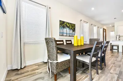 a dining room with a wooden table and chairs at Waters Edge Cottage Near Disney With Margaritaville Resort & Island H20 Access - 8129Su in Orlando
