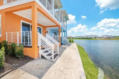 a house with a balcony and a body of water at Waters Edge Cottage Near Disney With Margaritaville Resort & Island H20 Access - 8129Su in Orlando