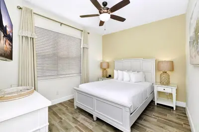 a bedroom with a white bed and a ceiling fan at Citrus Sunshine Villa Near Disney With Margaritaville Resort & Island H2O Access - 3049Cs in Orlando