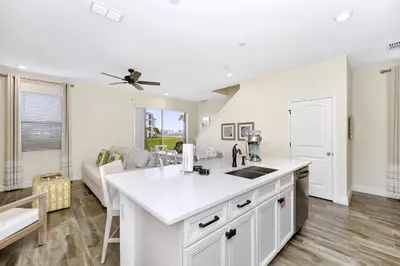 a kitchen with a white counter top and a living room at Citrus Sunshine Villa Near Disney With Margaritaville Resort & Island H2O Access - 3049Cs in Orlando