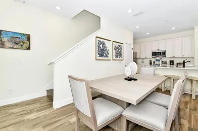 a kitchen and dining room with a wooden table and chairs at Orange Oasis Villa Near Disney With Margaritaville Resort & Island H20 Waterpark Access - 3097Cs in Orlando