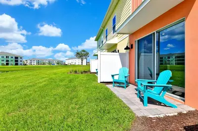 two blue chairs sitting on the side of a house at Orange Oasis Villa Near Disney With Margaritaville Resort & Island H20 Waterpark Access - 3097Cs in Orlando