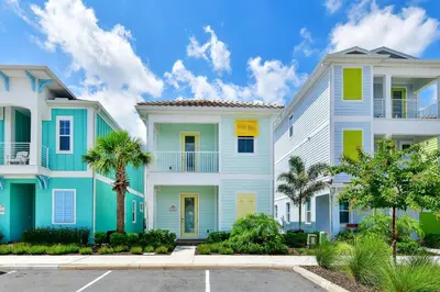 a row of houses with palm trees in a parking lot at Sandy Toes Cottage With Private Pool Near Disney And Margaritaville Resort & Island H2O Access - 8032St in Orlando