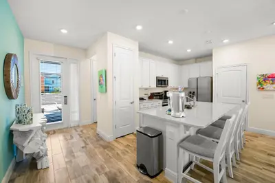 a kitchen with white cabinets and a counter with chairs at Caribbean Dream Villa Near Disney With Margaritaville Resort & Island H20 Waterpark Access - 2980Or in Orlando