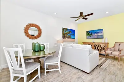 a living room with a white couch and a table at Lime Green Villa Near Disney With Margaritaville Resort & Island H20 Waterpark Access - 2972Or in Orlando