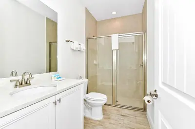 a white bathroom with a toilet and a shower at Lime Green Villa Near Disney With Margaritaville Resort & Island H20 Waterpark Access - 2972Or in Orlando