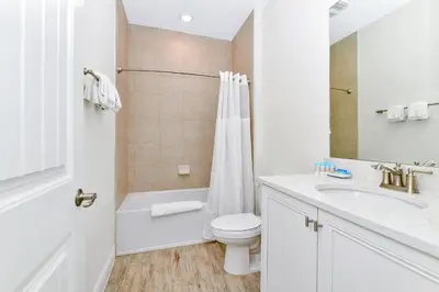 a white bathroom with a toilet and a sink at Pink Villa Near Disney With Margaritaville Resort & Island H20 Access - 8163Cp in Orlando