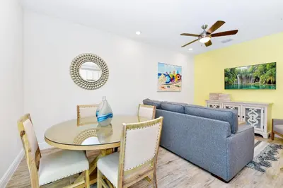 a living room with a dining room table and a couch at Pink Villa Near Disney With Margaritaville Resort & Island H20 Access - 8163Cp in Orlando