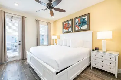 a bedroom with a white bed and a ceiling fan at Sunkissed Cottage With Private Pool Near Disney With Margaritaville Resort & Island H2O Access - 8024Kd in Orlando