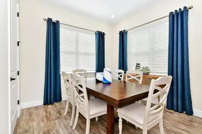 a dining room with a wooden table and chairs at Sunny Cottage With Private Pool Near Disney With Margaritaville Resort & Island H2O Access - 8021Kd in Orlando