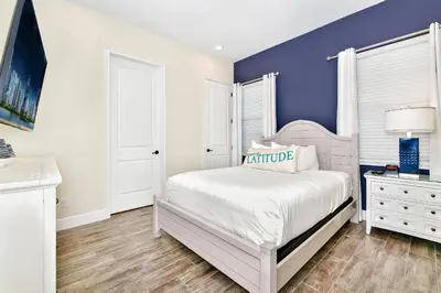 a bedroom with a white bed and a blue wall at Sunny Cottage With Private Pool Near Disney With Margaritaville Resort & Island H2O Access - 8021Kd in Orlando