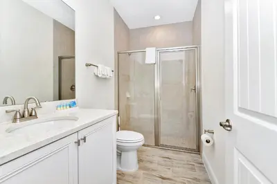 a white bathroom with a toilet and a shower at Bright Villa Near Disney With Margaritaville Resort & Island H20 Access - 8191Cp in Orlando