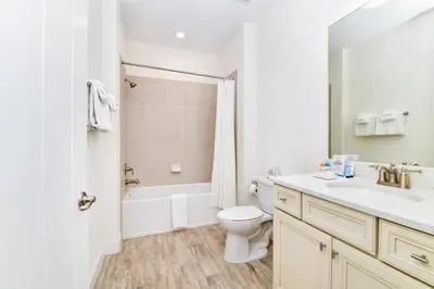 a white bathroom with a toilet and a sink at Luxurious Cottage Near Disney With Margaritaville Resort & Island H2O Access - 8000Dr in Orlando