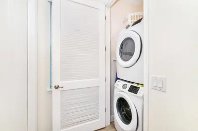 a laundry room with a washer and dryer next to a door at Luxurious Cottage Near Disney With Margaritaville Resort & Island H2O Access - 8000Dr in Orlando