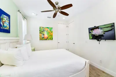 a bedroom with a white bed and a ceiling fan at Luxurious Cottage Near Disney With Margaritaville Resort & Island H2O Access - 8000Dr in Orlando
