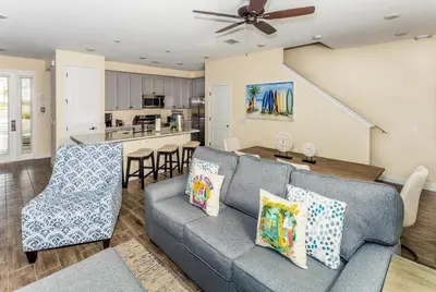 a living room with a couch and a kitchen at Breezy Villa Near Disney With Margaritaville Resort & Island H20 Access - 8177Su in Orlando