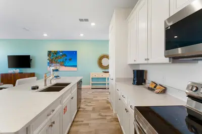 a kitchen with white cabinets and a sink at Bright And Cozy Villa Near Disney With Margaritaville Resort & Island H2O Access - 3053Cs in Orlando