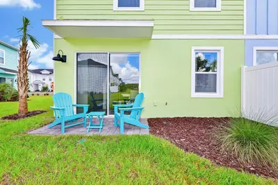 two blue chairs sitting on a patio in front of a house at Lime Green Villa Near Disney With Margaritaville Resort & Island H20 Waterpark Access - 2958Cl in Orlando