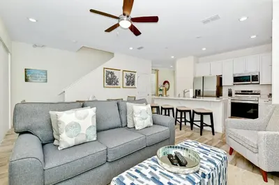 a living room with a couch and a kitchen at Lime Green Villa Near Disney With Margaritaville Resort & Island H20 Waterpark Access - 2958Cl in Orlando