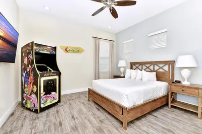 a bedroom with a video game machine next to a bed at Lively Cottage With Hot Tub Near Disney With Margaritaville Resort & Island H2O Access - 8030Su in Orlando
