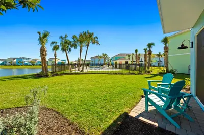 a blue bench sitting on a brick patio next to a yard at Tropical Villa Near Disney With Margaritaville Resort & Island H20 Waterpark Access - 2945Cs in Orlando