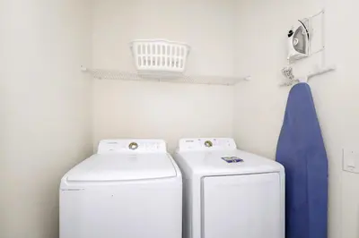 a laundry room with two washing machines and a towel at Orange Creamsickle Cottage Near Disney With Margaritaville Resort & Island H20 Waterpark Access - 2980Sr in Orlando