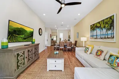 a living room with a couch and a tv at Orange Creamsickle Cottage Near Disney With Margaritaville Resort & Island H20 Waterpark Access - 2980Sr in Orlando