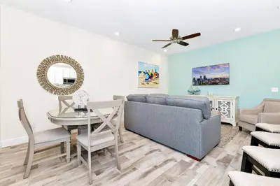 a living room with a couch and a table at Glimmering Blue Villa Near Disney With Margaritaville Resort & Island H20 Waterpark Access - 3016Cs in Orlando