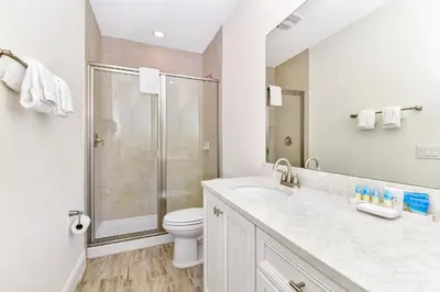 a white bathroom with a shower and a toilet at Sun Filled Villa Near Disney With Margaritaville Resort & Island H20 Access - 8183Cp in Kissimmee