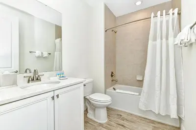a white bathroom with a toilet and a sink at Sun Filled Villa Near Disney With Margaritaville Resort & Island H20 Access - 8183Cp in Kissimmee