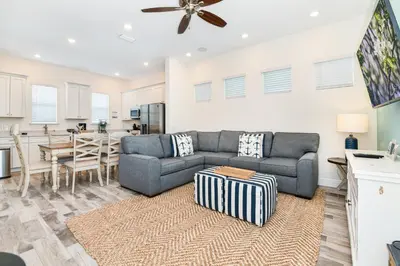 a living room with a couch and a table at Oasis Cottage Near Disney With Margaritaville Resort & Island H20 Waterpark Access - 2936Sr in Orlando