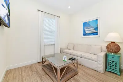 a living room with a couch and a table at Breezy Green Cottage With Private Hot Tub Near Disney With Margaritaville Resort & Island H2O Access - 3055Pi in Orlando