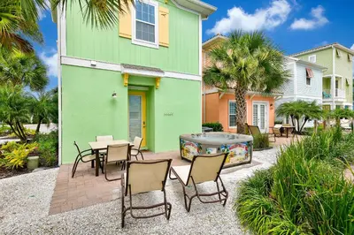a patio with chairs and a hot tub in front of a house at Breezy Green Cottage With Private Hot Tub Near Disney With Margaritaville Resort & Island H2O Access - 3055Pi in Orlando