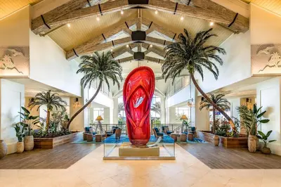 a large red surfboard in a room with palm trees at Tequila Sunrise Cottage With Private Hot Tub Near Disney With Margaritaville Resort & Island H2O Access - 8008Dr in Orlando