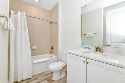 a white bathroom with a toilet and a sink at Sunny Villa Near Disney With Margaritaville Resort & Island H20 Access - 8151Cp in Orlando