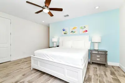 a bedroom with a white bed and a ceiling fan at Sunny Villa Near Disney With Margaritaville Resort & Island H20 Access - 8151Cp in Orlando