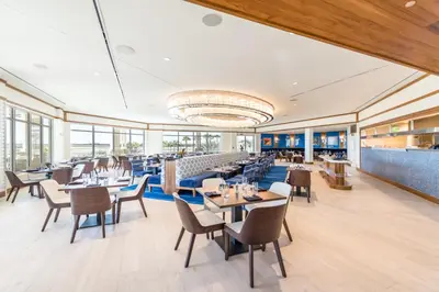 a restaurant with tables and chairs and windows at Ocean Blue Villa Near Disney With Margaritaville Resort & Island H20 Waterpark Access - 3101Cs in Orlando