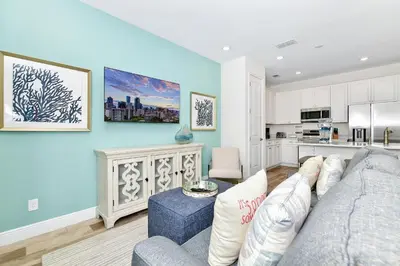 a living room with a couch and a kitchen at Ocean Blue Villa Near Disney With Margaritaville Resort & Island H20 Waterpark Access - 3101Cs in Orlando