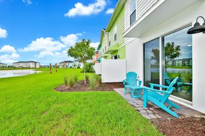 two blue chairs sitting on the front porch of a house at Relaxed Villa Near Disney With Margaritaville Resort & Island H20 Waterpark Access - 3169Cs in Orlando
