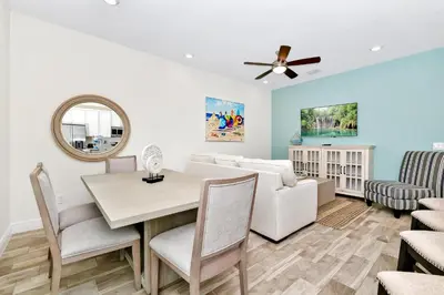 a dining room and living room with a table and chairs at Relaxed Villa Near Disney With Margaritaville Resort & Island H20 Waterpark Access - 3169Cs in Orlando