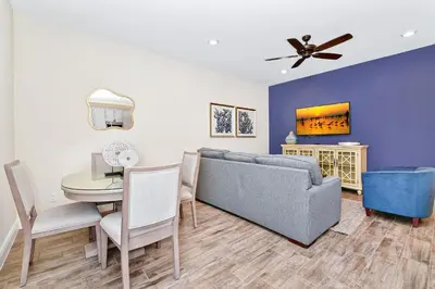 a living room with a blue couch and a table at Cozy Villa Near Disney With Margaritaville Resort & Island H20 Waterpark Access - 2976Or in Orlando